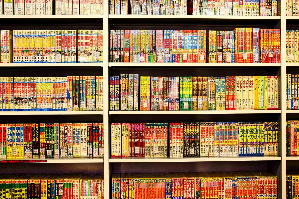 Jeune adulte lisant des mangas dans un coin cozy d'une librairie