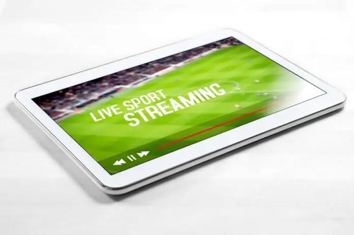 Live sport stream online with mobile device. White tablet on wooden table with imaginary video player and streaming service.